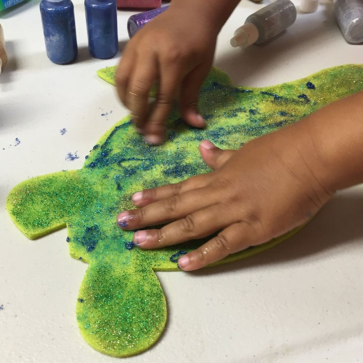 Adding glitter glue to felt shape