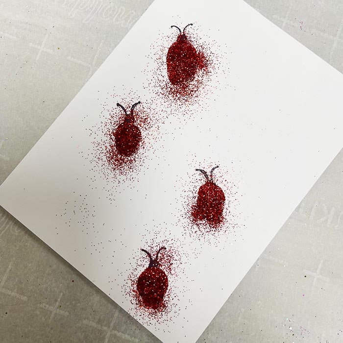 Adding red glitter to ladybugs
