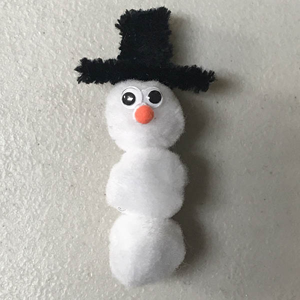 Googly eyes and pom pom nose added to snowman