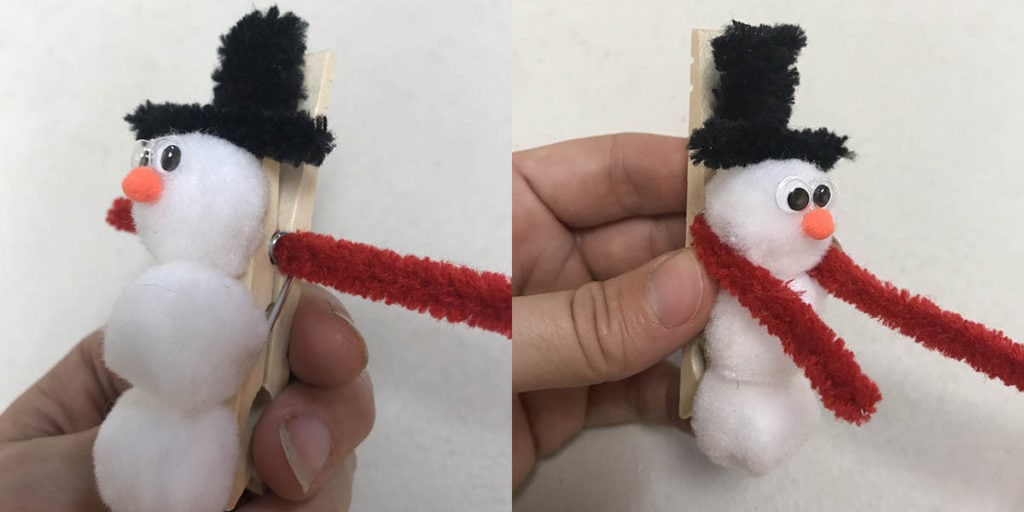 Pulling pipe cleaner scarf through hole in clothespin