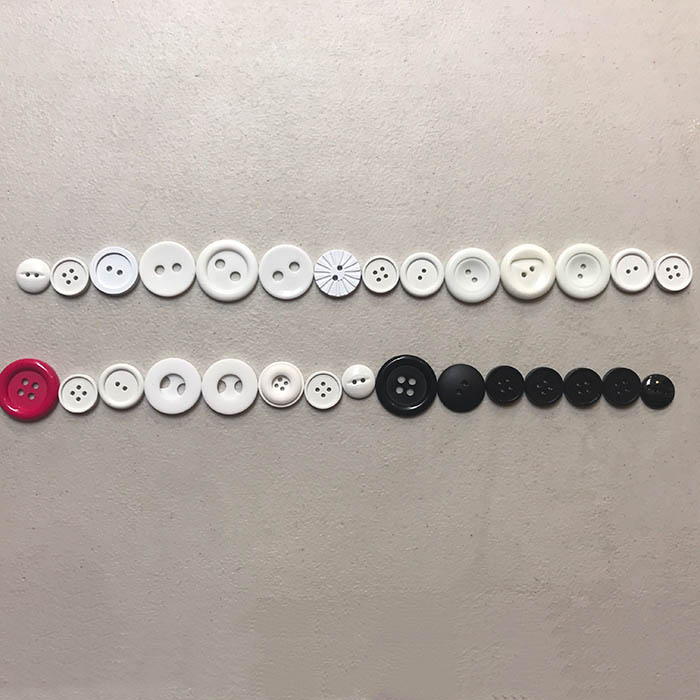 Laying out buttons for snowman Christmas ornament