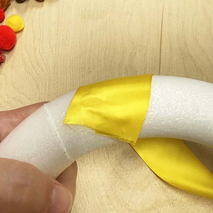 Attaching ribbon to wreath with hot glue