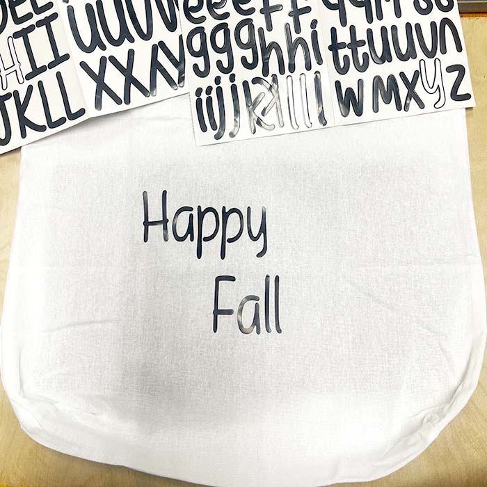 Adding letter stickers to happy fall bag