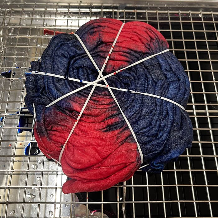 Dyeing the spider tie dye pattern with red and blue