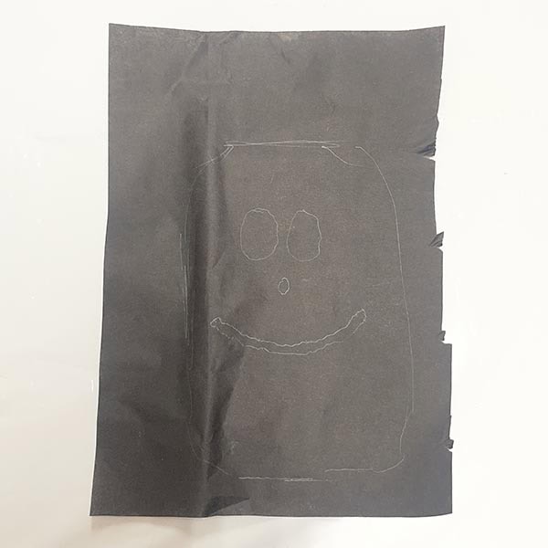 Drawing Frankenstein face on black tissue paper