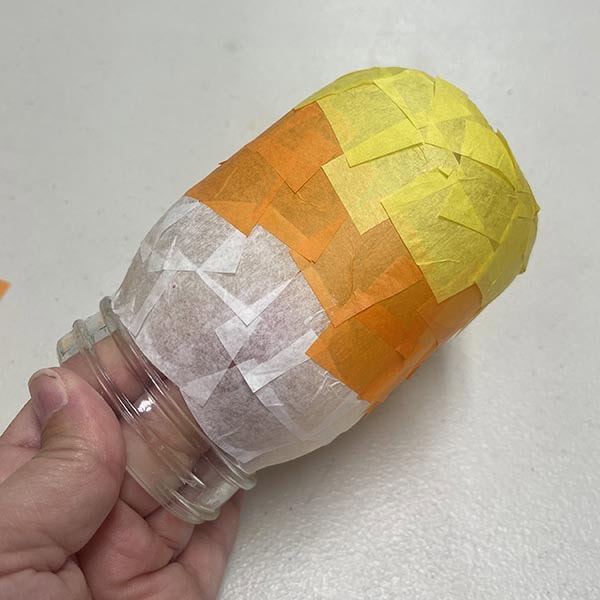 Adding first layer of tissue paper to candy cone jar