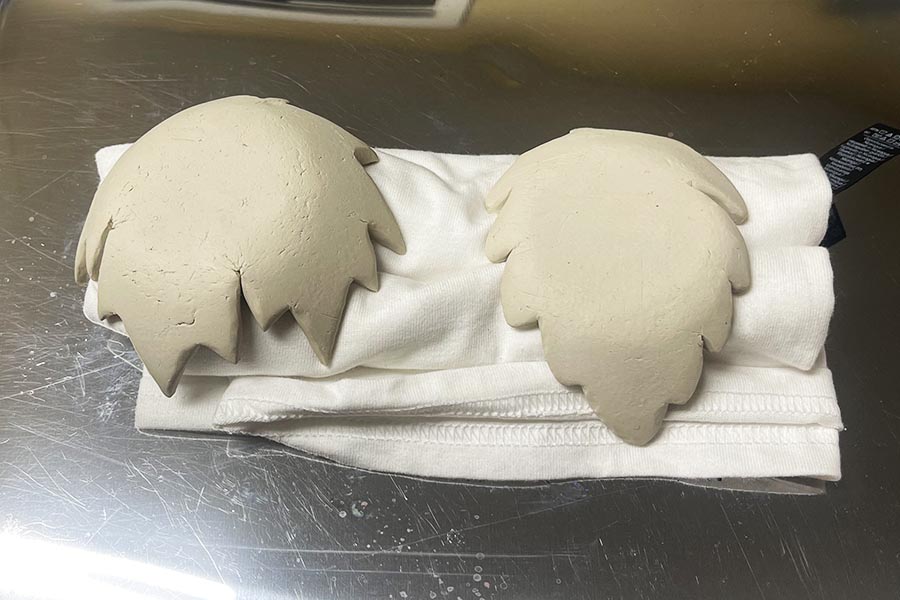 Clay leaf bowls flipped over on fabric support to dry